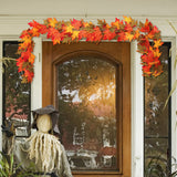 Maple leaf garland with warm lights, orange and yellow leaves across a window top