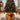 Gold Christmas tree collar basket with large red bow, lit with warm lights