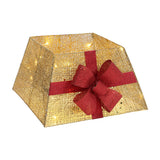 Gold glitter Christmas tree collar basket decor with burgundy bow, lit warm lights