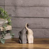 Ceramic elephant couple figurines, dark and cream elephants facing each other