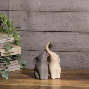 Ceramic elephant couple figurines, dark and cream elephants facing each other