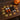 Assorted Halloween pumpkin and maple leaf ornaments on tabletop, orange white black