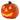 Close-up orange LED pumpkin lantern with carved triangular eyes and smiling mouth