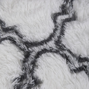 High-pile texture detail: white rug fibers with dark grey curved pattern lines