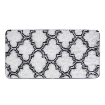 Close-up of grey-and-white geometric shag rug with quatrefoil trellis pattern