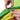 Hands fastening green and yellow sections with black strap on crawl tunnel