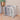 Foldable laundry basket with gray-and-cream fabric sides and metal supporting legs