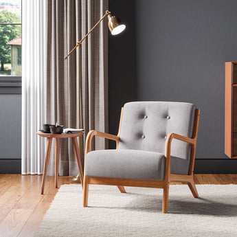 Grey tufted linen upholstered armchair with wooden arms and padded seat, front 3/4 view.