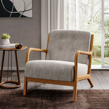 Grey linen armchair with button-tufted back, curved wooden arms, and padded seat, front view.