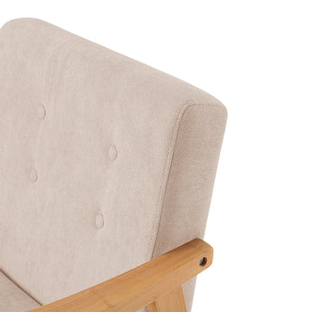 Close-up of beige upholstered armchair back corner and light wood arm support
