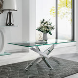 Glass-top metal table with chrome X legs, on patterned rug near window