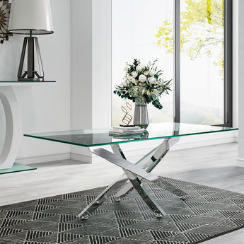 Glass-top metal table with chrome X legs, on patterned rug near window