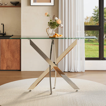 Metal table with clear glass top and diagonal X-frame legs