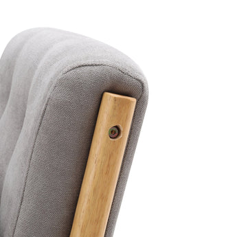 Light wood arm corner on grey upholstered rocking chair with visible mounting hardware