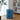 Blue round storage unit with two drawers and circular pull openings, compact cabinet.