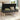 Dark gray velvet storage bench with hinged lid open, tufted seat and wooden legs.