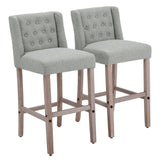Pair of gray linen bar stools with button-tufted backs and wooden frames