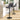Swivel bar stool with dark grey fabric seat, black base and footrest ring