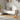 Light grey upholstered storage bench with rounded arms and wooden legs