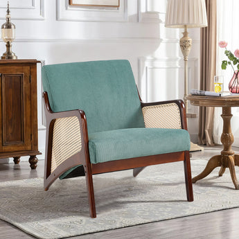 Green corduroy armchair with rattan armrests, dark wood frame, wide seat and backrest