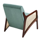 Green corduroy armchair angled view, rattan armrests, dark wood frame and tapered legs