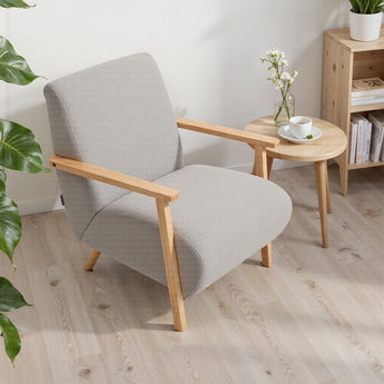 Grey chenille upholstered armchair with light wood arms and angled legs.