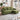 Green chaise sectional sofa with metal stud trim on arms and dark tapered legs