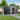 Steel garden storage shed with gable roof, side door open showing shelving and supplies inside.