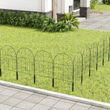 Black arched metal garden border fence panels with scrollwork along a walkway edge