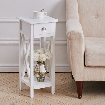 White wooden side table with drawer and open shelf, top with decor