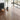 Self-adhesive wood-grain PVC plank flooring in light gray-brown tone