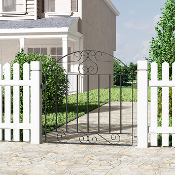 Black wrought iron pedestrian gate with arched top and vertical bars, installed outdoors.