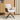 Adjustable accent chair with beige linen seat, brown arm panels, black tripod legs