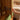 Soft-close cabinet hinge on wooden cabinet door, brushed metal fastener