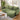 Green L-shaped corner sofa with chaise and three back cushions, front three-quarter view.