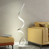 LED spiral floor lamp with glowing white wavy light tube and round white base.