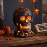 Black skull table decoration with glowing orange eyes, detailed teeth, and crack accents