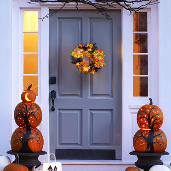 Halloween wreath with orange, yellow, and black leaves and pumpkin-themed decorations