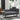 Grey linen chaise lounge with attached round wooden tray table and back cushion