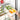 Three-compartment fridge container holding sliced vegetables and eggs in a clear lid