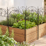 Black decorative garden fence with arched scrollwork top and vertical bars in outdoor yard