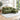 Green polyester sofa with chaise, metal rivet trim, cushioned back and seat