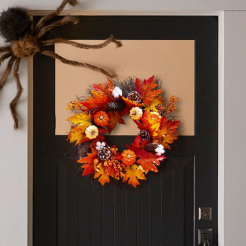 Autumn wreath with orange maple leaves, pinecones, mini pumpkins, and berry clusters