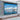 Motorized projector screen with black frame, wall-mounted roller housing