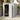 Plastic storage shed with open double doors showing interior shelves/tools