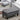 Gray tufted upholstered bench with nailhead trim and dark tapered legs