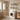 White 2-tier over-washer storage rack with shelves holding bath bottles above a washer