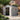 Gray outdoor storage shed with wide-open double doors, tool storage view