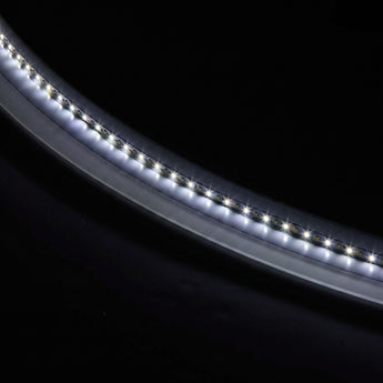 Oval frameless bathroom mirror with built-in LED strip, close-up of glowing edge