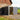 Metal storage shed with open double doors, dark gray siding and white door panels